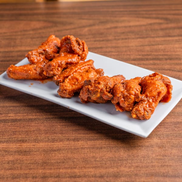 DeAngelo's Neapolitan Italian Eatery's spicy chicken wings on a white rectangular plate.